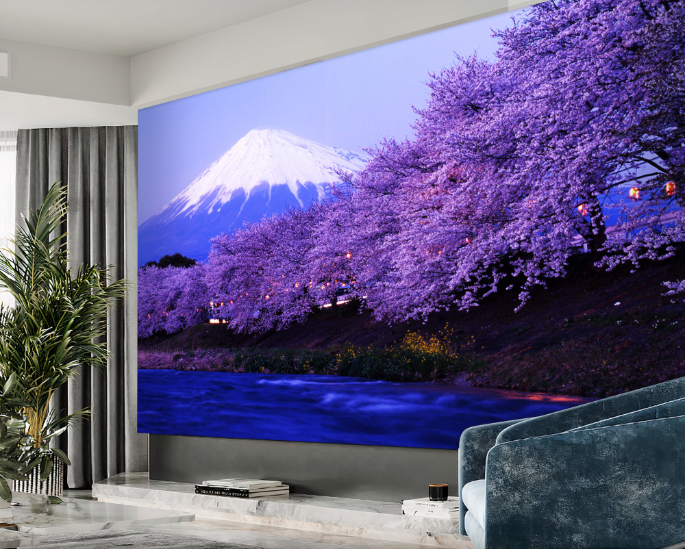 Fototapeta liliowe kwiaty drzew w pobliżu wody u podnóża góry