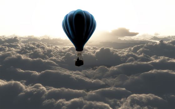 Fototapeta balon na ogrzane powietrze unosi się nad grubymi chmurami